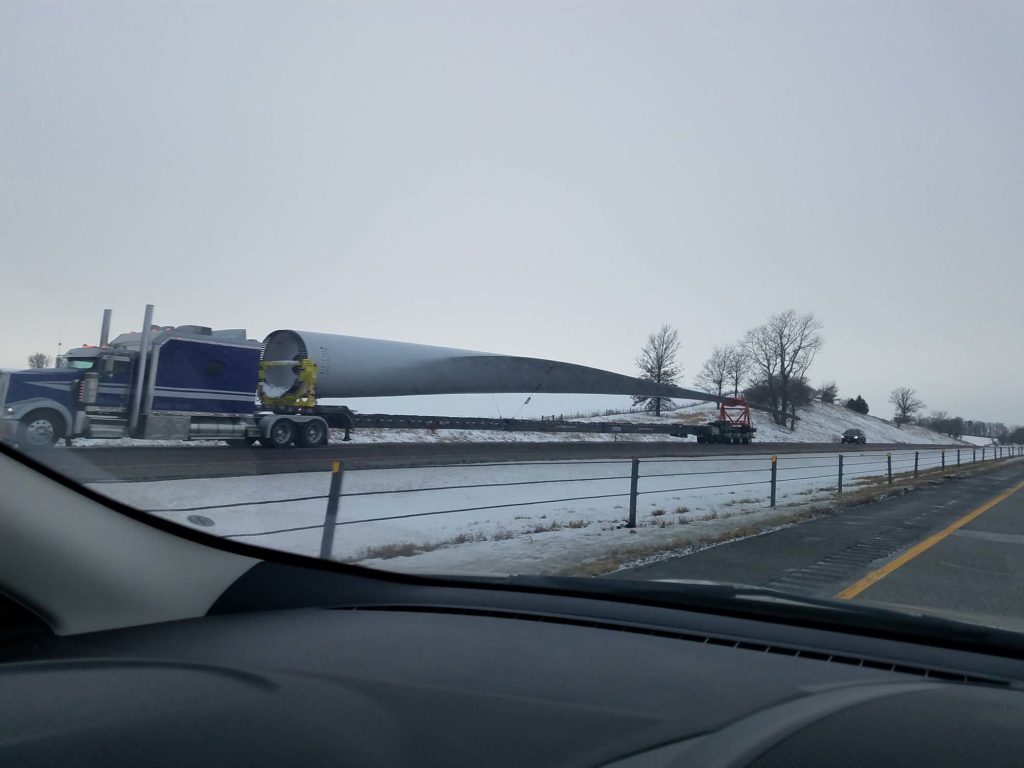 Massive windmill blade being hauled on a truck trailer